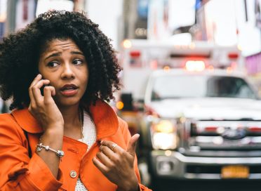 afro american woman calling 911 in New york city. concept about car accidents and emergency